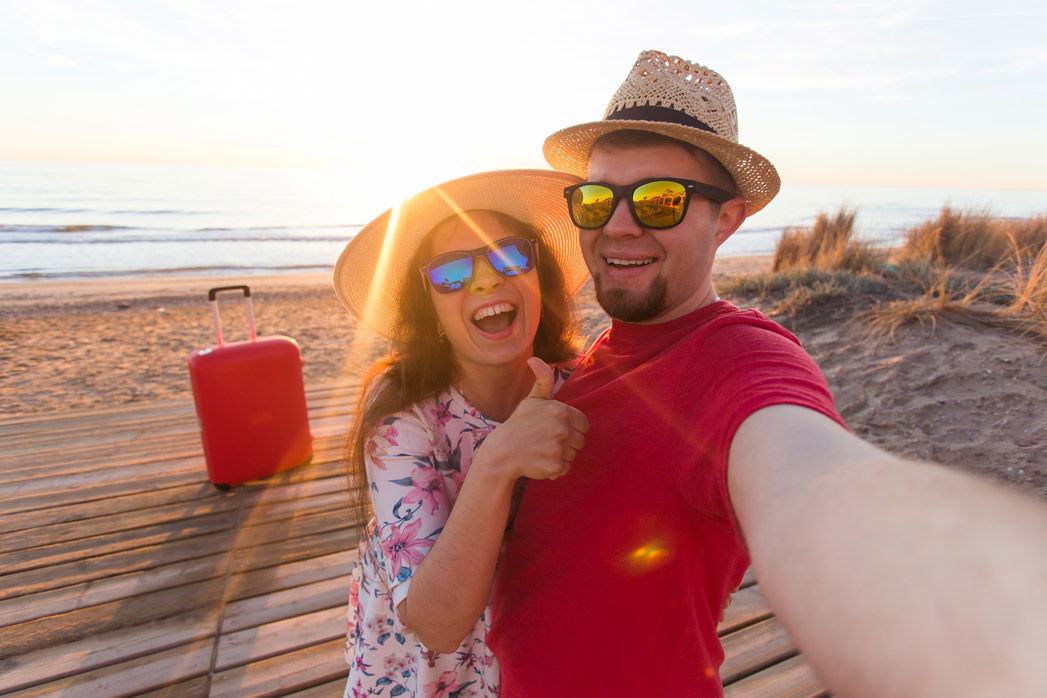 happy-friends-enjoying-beach-against-sky